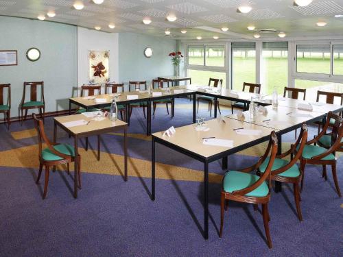 a large room with tables and chairs in it at ibis Site du Futuroscope in Chasseneuil-du-Poitou