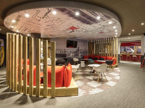 a lobby with a waiting area with chairs and tables at ibis Marseille Timone in Marseille