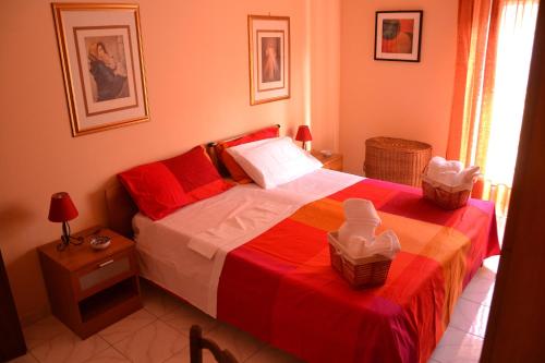 マスカリにあるHoliday House Etna Mare Taorminaのベッドルーム1室(赤と白のベッド1台、バスケット付)
