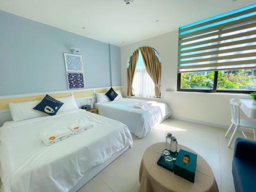 a hotel room with two beds and a table at Timo Homestay Phòng Máy Chiếu in Hue