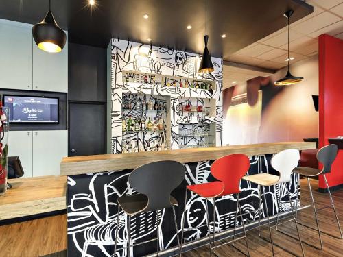 a bar with colorful stools in a restaurant at Ibis Agen Centre Gare in Agen