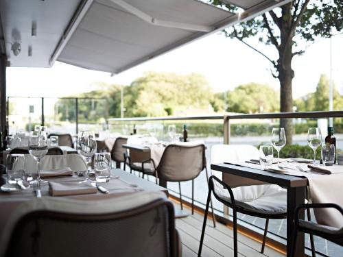 un restaurant avec des tables et des chaises et des verres à vin dans l'établissement Holidaysuite Mathilda, à Ostende