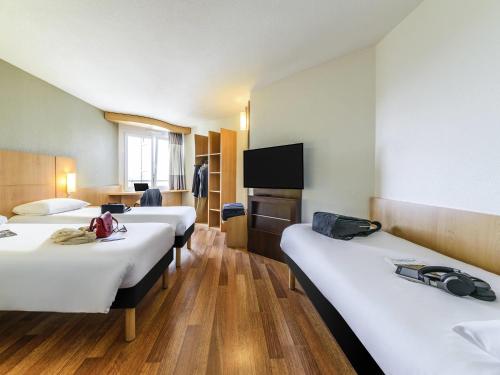Una cama o camas en una habitación de ibis Lausanne Crissier