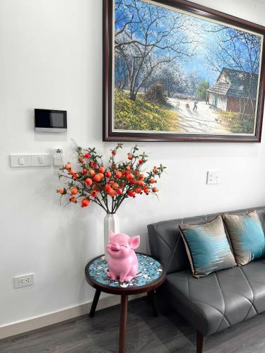 a vase of flowers on a table next to a couch at Châu Giang Homestay, Nera Garden Huế in Thôn Văn Dương