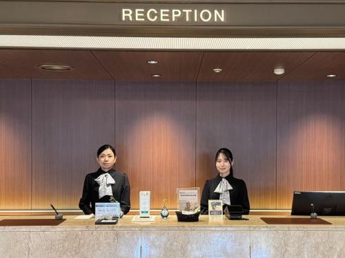 two women sitting at a reception desk with bows at Takamatsu Kokusai Hotel in Takamatsu