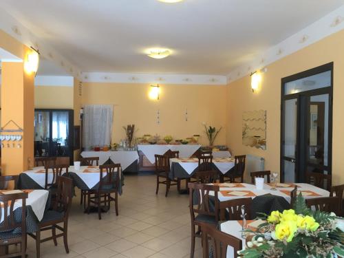 a restaurant with tables and chairs in a room at Hotel Villa Elle in Loano