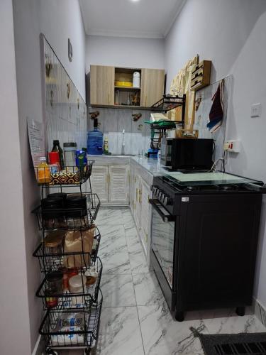 a kitchen with a black stove and cabinets at The Nest Haven in Malindi