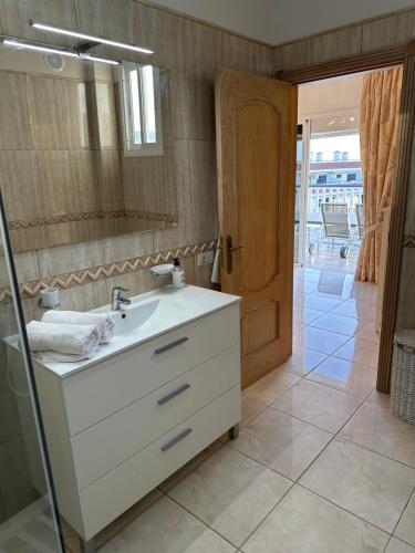 a bathroom with a white sink and a mirror at Villa Alexander in Puerto de Santiago