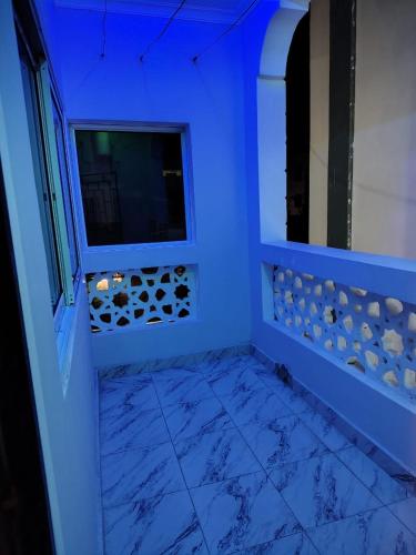 a blue room with a window and a mirror at The Nest Haven in Malindi