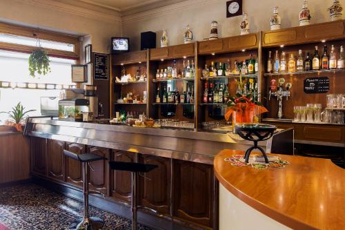 - un bar avec un comptoir et des bouteilles d'alcool dans l'établissement Hotel Susa & Stazione, à Suse