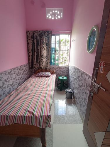 a bedroom with a bed in a pink room at SRI Ganesh Hotel Fooding & Lodging in Bongaigaon