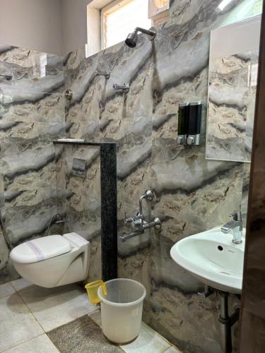 a stone bathroom with a toilet and a sink at Air Avenue Hotel - Airport in Devanahalli-Bangalore