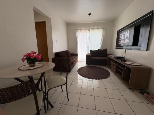 a living room with a couch and a table and a television at Aluguel Círio , COP-30 apartamento todo mobiliado in Ananindeua