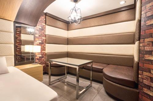 a room with a bed and a table and a chair at Victoria Court Las Pinas in Manila