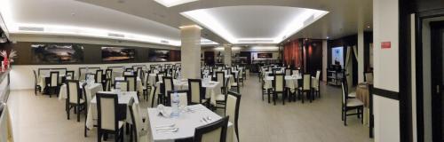 a room with tables and chairs in a restaurant at Hotel Aleluia in Fátima