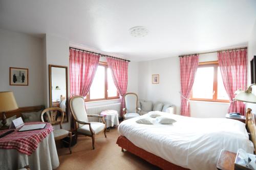 Logis Hotel Restaurant Au Boeuf Rouge في Niederschaeffolsheim: غرفة نوم بسرير وكراسي ونوافذ