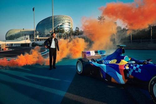 a man is standing next to a racing car at W Abu Dhabi - Yas Island in Abu Dhabi