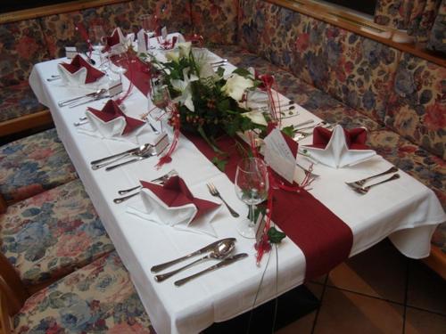 a table with a white table cloth and red napkins at Hotel-Restaurant Schweinberger in Stetten