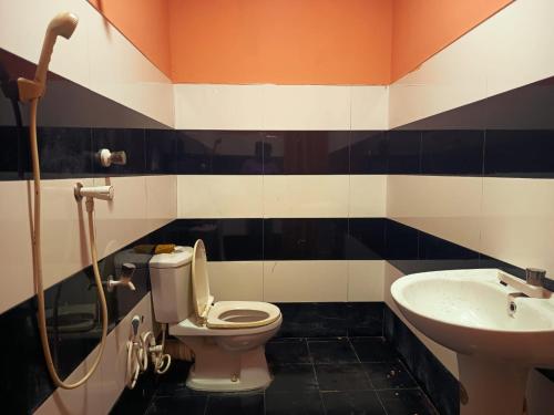 a bathroom with a toilet and a sink at Warm Whisky Rooms in Pottuvil