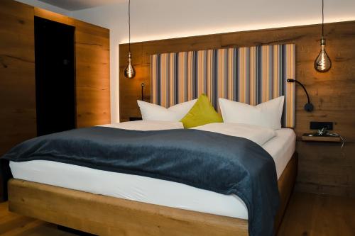 a large bed with white sheets and yellow pillows at Altstadt-Hotel in Freiberg