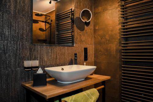 a bathroom with a white bowl sink on a wooden counter at Altstadt-Hotel in Freiberg
