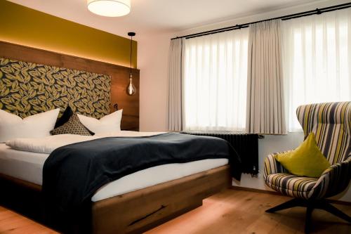 a bedroom with a bed and a chair at Altstadt-Hotel in Freiberg