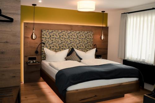 a bedroom with a large bed with a yellow headboard at Altstadt-Hotel in Freiberg