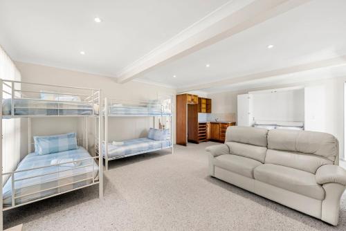 a living room with bunk beds and a couch at Ocean Echoes - Pet Friendly with Ocean Glimpses in Culburra Beach