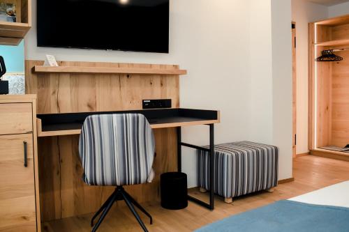a desk with a television and a chair in a room at Altstadt-Hotel in Freiberg