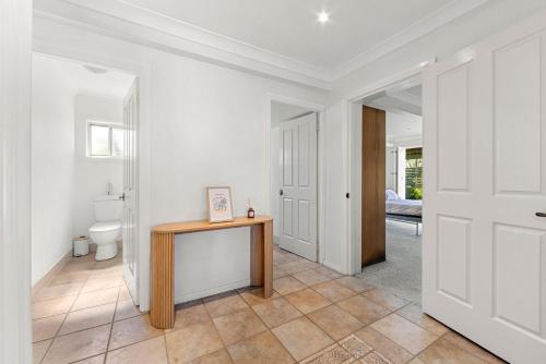 a hallway with a bathroom with a toilet and a table at Ocean Echoes - Pet Friendly with Ocean Glimpses in Culburra Beach