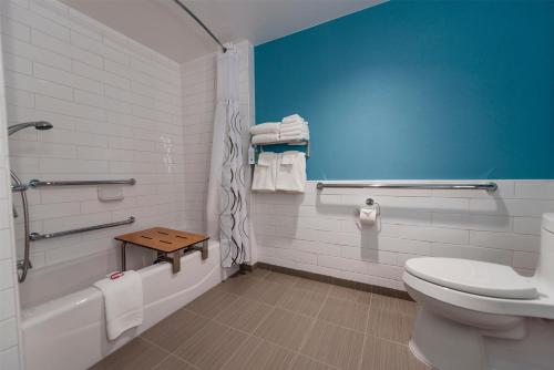 a bathroom with a toilet and a tub and a sink at Howard Johnson by Wyndham Anaheim Hotel & Water Playground in Anaheim