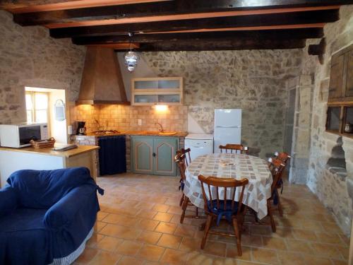 cocina y comedor con mesa y sillas en L'Oustal dè Pèiro, en Le Bourg
