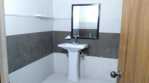 a bathroom with a sink and a mirror at Premier Inn Heights hotel Davis Road Lahore in Lahore