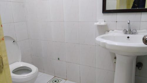 a white bathroom with a sink and a toilet at Premier Inn Heights hotel Davis Road Lahore in Lahore