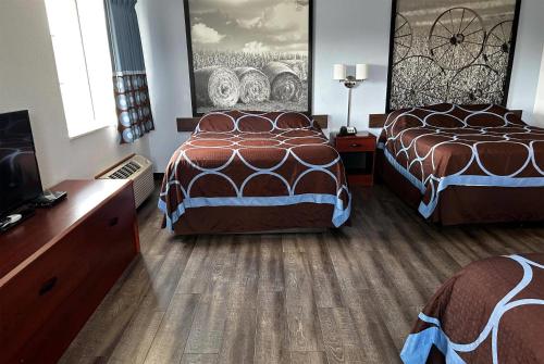 a hotel room with two beds and a flat screen tv at Super 8 by Wyndham Ida Grove in Ida Grove