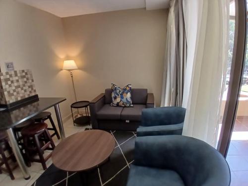 a living room with a couch and a table at ATKV Klein-Kariba in Bela-Bela