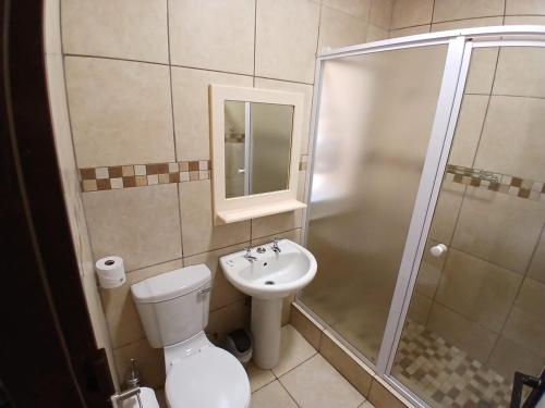 a bathroom with a shower and a toilet and a sink at ATKV Klein-Kariba in Bela-Bela