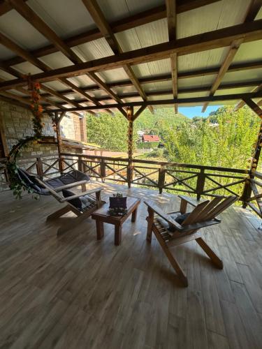 a porch with two chairs and a table and a hammock at Vila Simona in Mavrovo