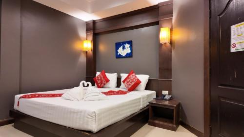 a bedroom with a bed with red and white pillows at The Great Residence Suvarnabhumi Airport in Lat Krabang