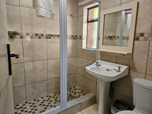 a bathroom with a shower and a sink at ATKV Klein-Kariba in Bela-Bela