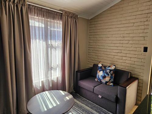 a living room with a couch and a window at ATKV Klein-Kariba in Bela-Bela