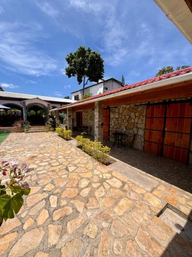 a stone patio next to a building with a tree at Azomalli Hotel Boutique in Damían Carmona