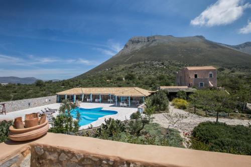 a villa with a swimming pool in front of a mountain at Ktima Karageorgou in Areopolis
