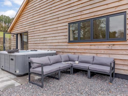 a bench and a hot tub next to a house at 5 Bed in Dulverton 87003 in Morebath