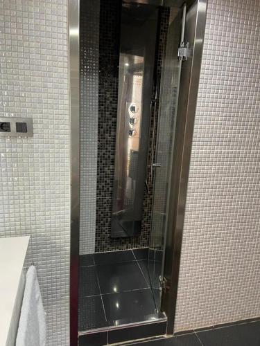a shower in a bathroom with a glass door at Appartement mobilart haut standing in Oran