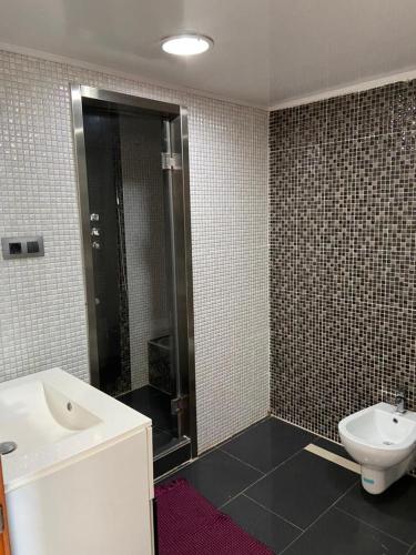 a bathroom with a toilet and a sink and a shower at Appartement mobilart haut standing in Oran