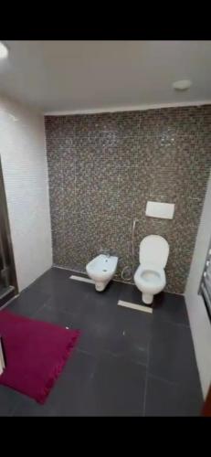 a bathroom with two toilets and a pink rug at Appartement mobilart haut standing in Oran