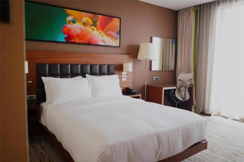 a hotel room with a large bed and a tv at DoubleTree by Hilton Trabzon in Trabzon