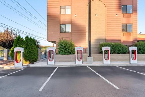 a parking lot with four pay phones in front of a building at Baymont by Wyndham Yakima Riverfront in Yakima