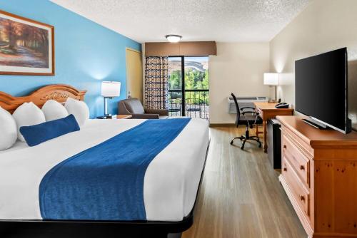 a hotel room with a bed and a flat screen tv at Baymont by Wyndham Yakima Riverfront in Yakima